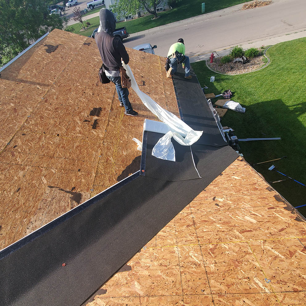 Photo of staff installing a new roof on an older home.