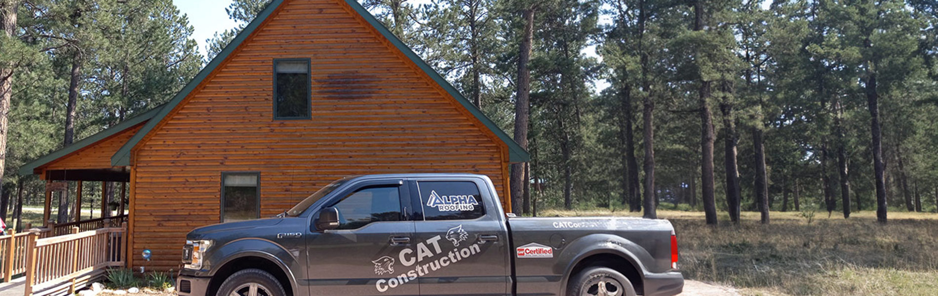 Photo of CAT Construction Inc. truck outside of a newly shingled cabin.